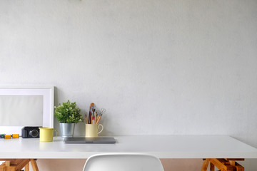 Stylish workspace with poster and gadget..Workplace desk and copy space.