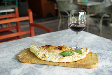 Italian Kalzone pizza with a basil garnish on the table in the restaurant