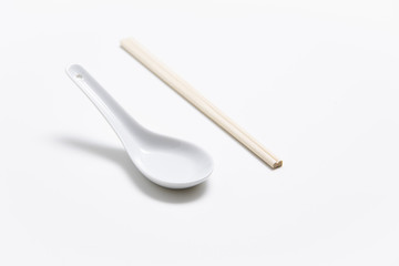 Chinese porcelain spoon and wooden chopsticks isolated on white