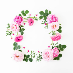 Floral frame made of rink roses and leaves on white background. Flat lay, top view. Flower background