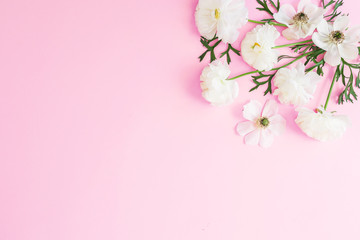 White flowers and petals on pink pastel background. Flat lay, top view. Floral pattern