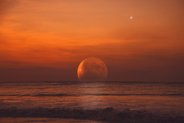 Obraz premium Rising Moon eclipse from the ocean horizon.