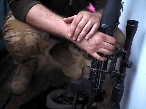 soldier hands and Sniper rifle close up. war.