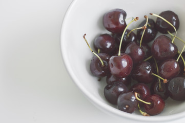 Plate with fresh cherry berries on white background. Bowl with cherries