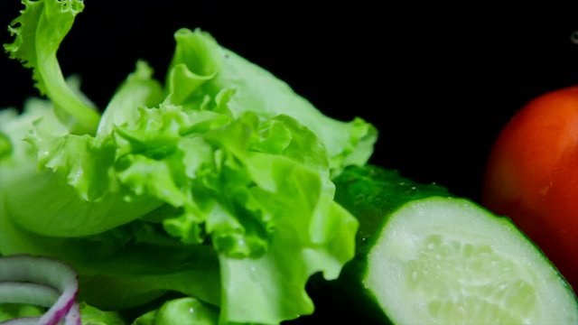 Close up of fresh vegetables and tasty burger with cheese and beef cutlets on the black background