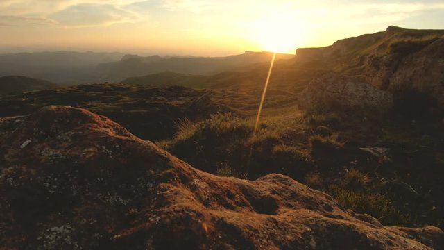 Mountain sunset over the peak rock. Dark key sunset light in the mountains parallax rocks rock grass