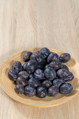 Top view on a wooden basket full of ripe plums