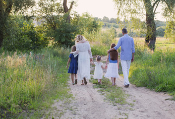 Fototapeta premium happy family in summer park at sunset