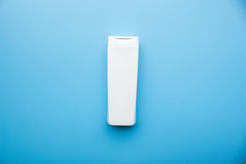 White plastic bottle shampoo and conditioner on blue background