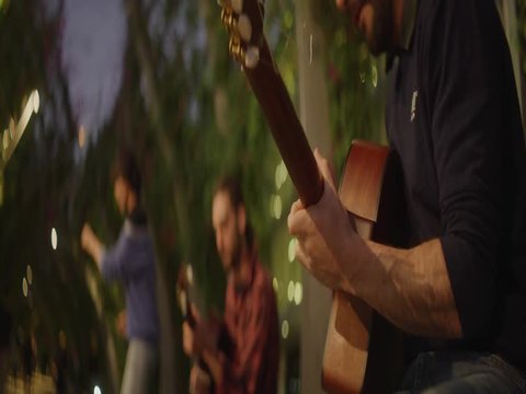 Buskers playing guitar in street at dusk