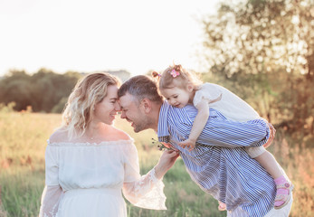 Naklejka premium happy family in summer park at sunset