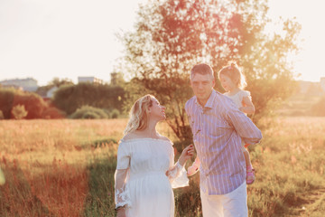 happy family in summer park at sunset