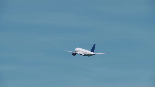 White aircraft with a blue tail took off from the airport and is gaining height