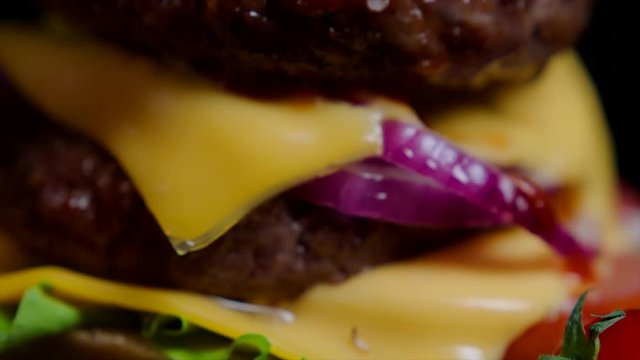 Close up of burger bun with sesame, greens, cheese and beef for commercial use