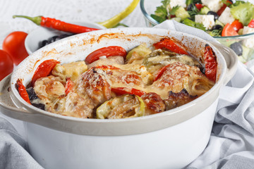 Traditional tasty rustic stew of chicken and vegetables  with Greek salad and black olives