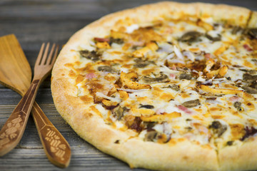 round carbonara pizza with Mozzarella cheese on an old wooden table