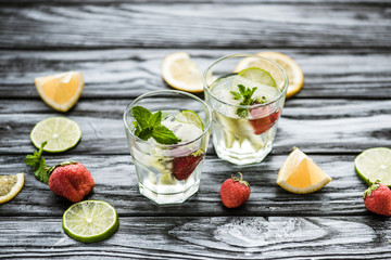 high angle view of delicious strawberry mojito cocktail in glasses on wooden table