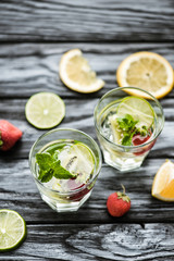 top view of glass with fresh cold strawberry and kiwi mojito on wooden table