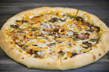 round carbonara pizza with Mozzarella cheese on an old wooden table