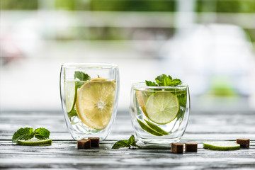 close-up view of two glasses with fresh cold mojito on table