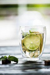 glass of cold fresh mojito with lime, mint and sugar