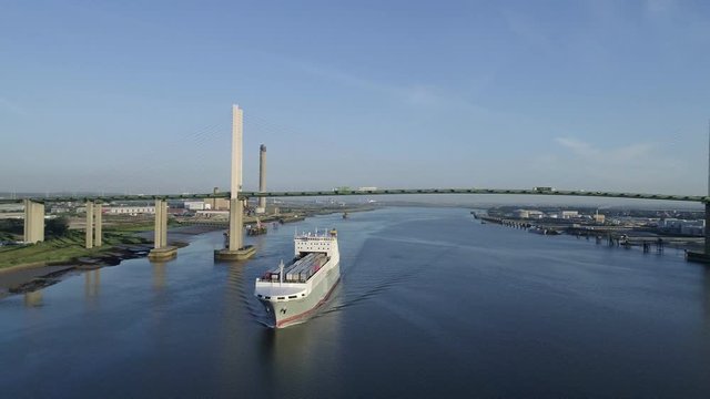 Drone tracks around ro-ro cargo ship Adeline passing under Queen Elizabeth II Bridge