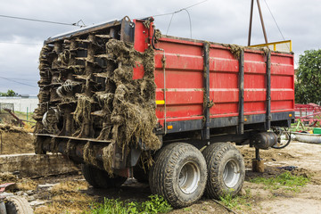 Agricultural machinery on a dairy farm. Trailer-distributor of organic fertilizers from cow manure and straw after working in the field. General view.