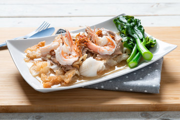 Fried noodles with pork , squid , shrimp and kale in gravy sauce