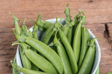 Pod of green pea , green peas, on wood background