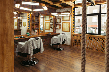 empty chairs and mirrors in modern barbershop interior
