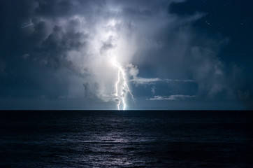 Naklejka na ściany i meble Lightning in the sea with high clouds
