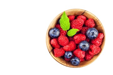 Fresh blueberries with raspberries isolated on white. Healthy berries. Collecting raspberries and blueberries. Fruit Advertising.