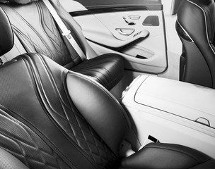 Modern Luxury car inside. Interior of prestige modern car. Comfortable leather seats. Black perforated leather. Back passenger seats. Car detailing. Black and white