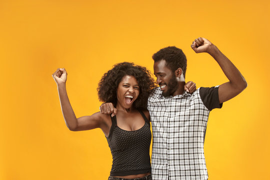 Winning success couple celebrating being a winner. Dynamic energetic image of afro models