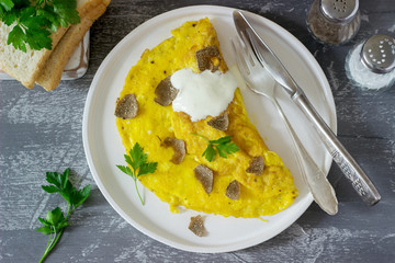 Omelette with truffle and parsley, served with sour cream, bread and a glass of fresh water.