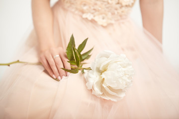 Fototapeta na wymiar Beautiful Woman in Lace Wedding Dress. Woman with a peony. Wedding Decoration