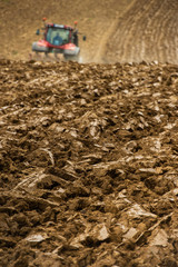 Farmer on tractor plow field, France