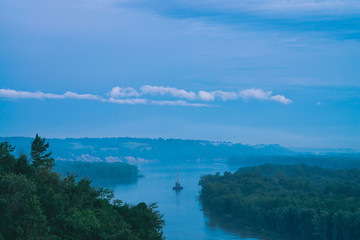Beautiful river night landscape with green shores and ship with copy space. Towboat tows barge with...