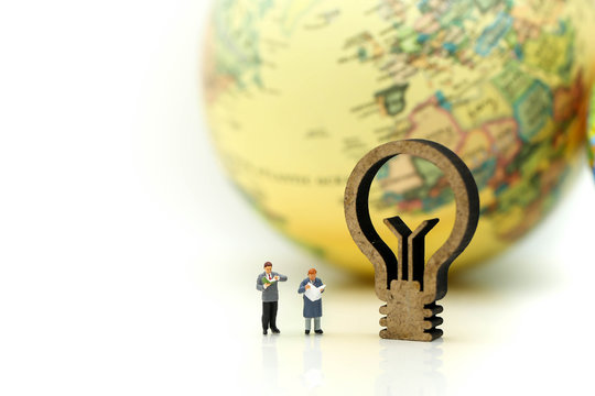 Miniature people : reading a book with sign of lamp idea and world map,Education business concept.