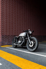 Custom motorcycle parking near brick wall of finance building. Everything is ready for having fun driving the empty road on a motorcycle tour journey. City hobby. Space for your individual text. - 214189108