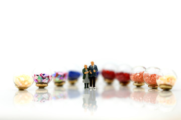 Miniature people : couple of love  with Colorful of candies and lollipops,Lover and food concept.