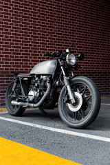 Caferacer motorcycle parking near brick wall of finance building. Everything is ready for having fun driving the empty road on a motorcycle tour journey. City hobby. Space for your individual text. - 214189130