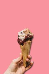The girl is holding a delicious ice cream in her hand in a minimal style on a pink background. Summer concept