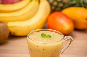 Tropical fresh fruit set and juice smoothies isolated with wooden background