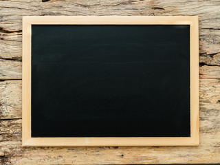 empty blank black chalkboard with wooden border frame on crack wooden background