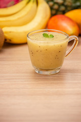Tropical fresh fruit set and juice smoothies isolated with wooden background