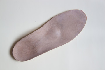 Leather orthopedic insole for footwear on beige background