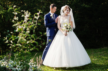 Young romantic wedding couple enjoying each other's company in the forest or park.