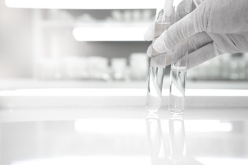 two of test tube holding by hand of scientist in medical clean white laboratory background