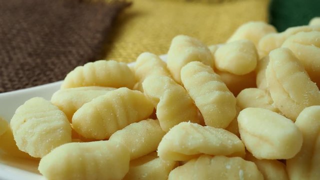 Uncooked homemade potato gnocchi in a white bowl